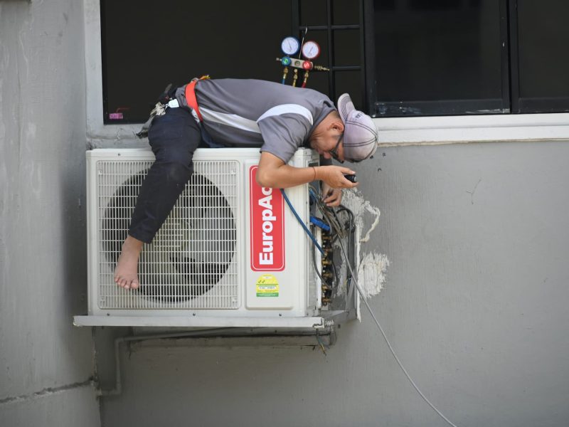 HVAC technician repairing air conditioner unit in Fontana CA