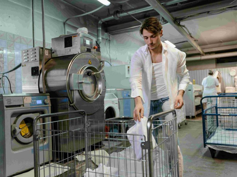 Professional technician repairing a high-end clothes dryer in a Fontana home laundry room.